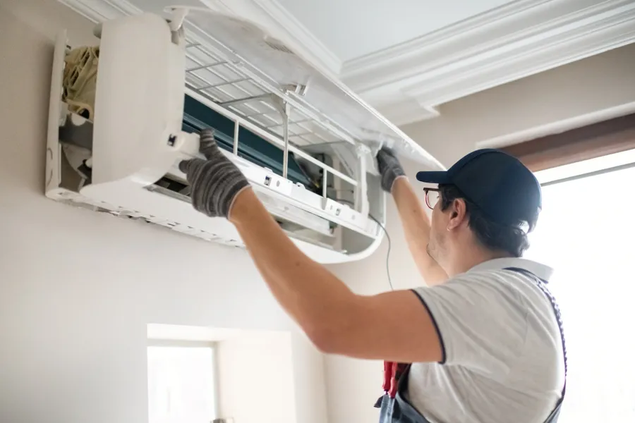 Professional AC technician servicing an air conditioner